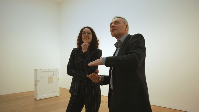 Ministerin Dorn und Kurator Foster stehen im Museum Wiesbaden und betrachten ein Kunstwerk, das sich auÃerhalb der Kamera befindet.