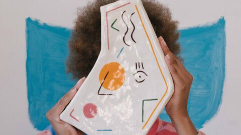 Die Hessische Kulturstiftung vergibt auch Stipendien an Künstlerinnen und Künstler Eine PoC-Frau hält sich ein Stück Keramik vors Gesicht