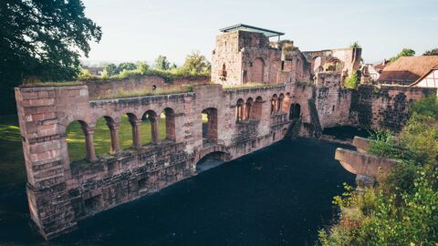 Die Kaiserpfalz Gelnhausen; zu sehen ist die romanische Wasserburg, rötiche Mauern mit Bogenfenstern
