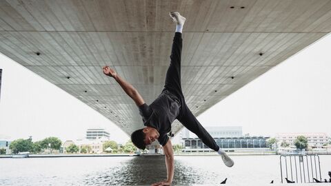 Ein Breakdancer tantzt unter einer Brücke