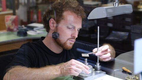 Ein Uhrmacher sitzt an seinem Arbeitsplatz