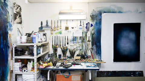 Blick in ein Maler-Atelier mit großer Leinwand, Pinseln und Werkzeugen