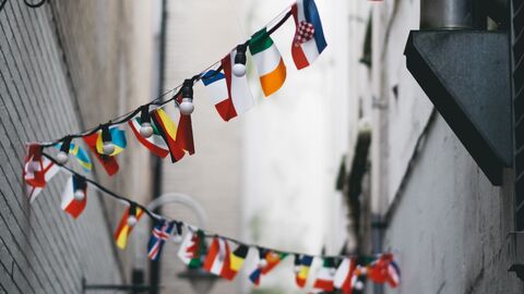 Hessen fördert den Austausch auf internationaler Ebene Kleine Fahnen verschiedener Länder hängen zwischen zwei Hauswänden