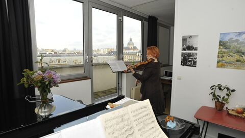 Eine Violinistin im Atelier der Cité Internationale des Arts in Paris Eine Frau steht in einem Atelier der Cité internationale des Arts in Paris und spielt Geige