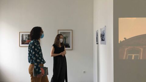 Ministerin Dorn steht im Atelier und schaut sich die Projektionskunst einer Künstlerin an