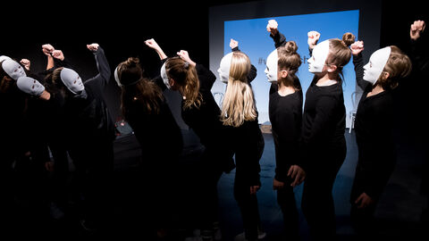 Der Kulturkoffer ist ein wichtiger Baustein der kulturellen Bildung in Hessen Schwarz gekeidete Jugendliche mit weiße Masken stehen sich gegenüber und heben die Fäuste