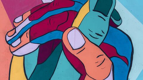 Zwei ineinander verschränkte, bunte Hände