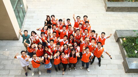 VGU-Studierende in rotn T-Shirts, von oben fotografiert, winken in die Kamera
