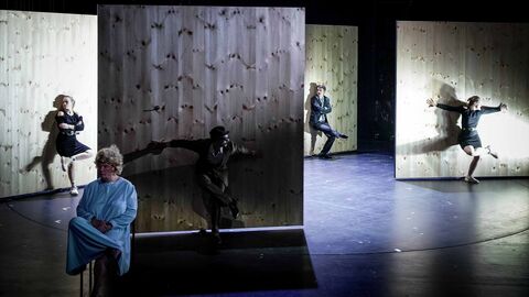 Ein Beispiel für Olaf Altmanns reduzierten Stil: Das Bühnenbild von "Die stillen Trabanten" am Deutschen Theater Berlin. Szene aus "Die stillen Trabanten": Auf der Bühne sind einzelne Holzwände aufgebaut, um die die Schauspieler herumspielen