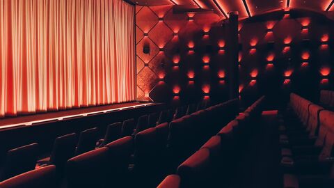 Kinosaal mit roten Sitzen und Vorhang