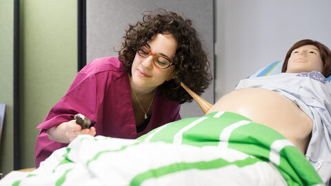 In Fulda, Frankfurt und Gießen wird es künftig insgesamt mindestens 140 Studienplätze pro Jahr für Hebammen geben Eine angehende Hebamme hört mit einem Gerät den Bauch einer Puppe ab, die eine Schwangere darstellt