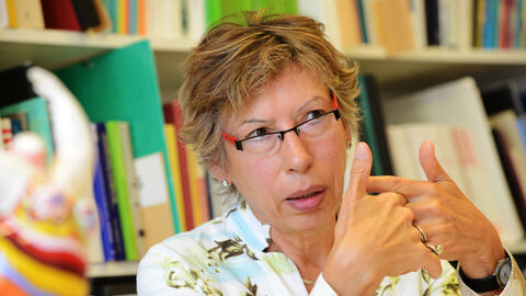 Prof. Dr. Helma Lutz in einer Gesprächssituation vor einem Bücherregal