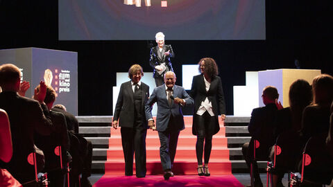 Laudatorin Lilo Mangelsdorff, Ehrenpreisträger Volker Schlöndorff, Kunst- und Kulturministerin Angela Dorn. Im Hintergrund: Moderatorin Bärbel Schäfer Laudatorin Lilo Mangelsdorff, Ehrenpreisträger Volker Schlöndorff, Kunst- und Kulturministerin Angela Dorn. Im Hintergrund: Moderatorin Bärbel Schäfer