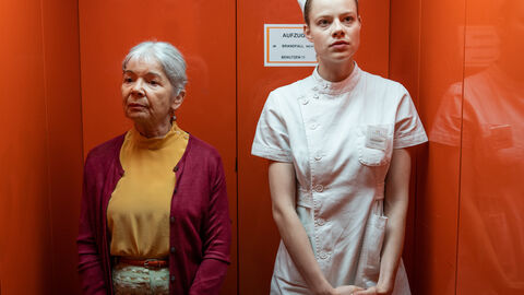 Szene aus "Klabautermann": Eine Krankenschwester und eine ältere Frau stehen im Aufzug