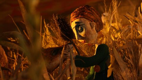 Szene aus "Fuchskind" Szene aus "Fuchskind": Eine Puppenfigur steht in einem Getreidefeld und streichelt einen Fuchs