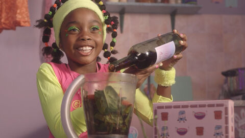 Szene aus "First work, then play" Szene aus "First work, then play": Ein Mädchen kippt Wein in einen Mixer