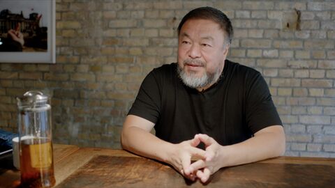 Szene aus "Why are we creative" Szene aus "Why are we creative": Der Künstler Ai Weiwei sitzt an einem Tisch und spricht