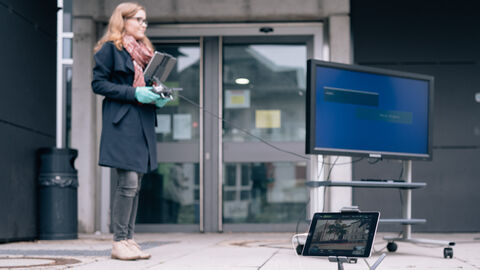 Eine Studentin mit einer Drohne und technischem Equipment