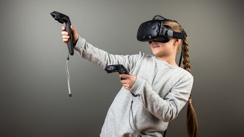 Ein Mädchen trägt ein Virtual Reality Headset und Controller
