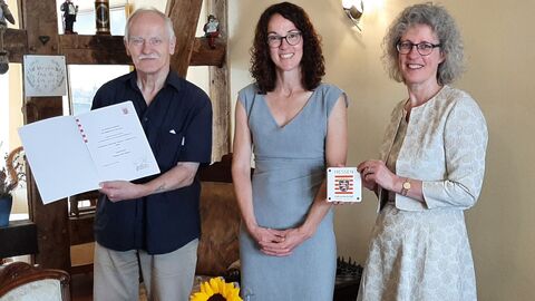  Kirsten Ranft und Hans-Ulrich Werchner-Ranft halten Urkunde und Plakette, zwischen ihnen steht lächelnd Kunstministerin Angela Dorn