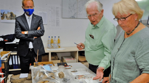Der Chef der Hessischen Staatskanzlei, Staatsminister Axel Wintermeyer, informiert sich über die ehrenamtliche Arbeit des Ehepaares Grabsch Staatsminister Axel Wintermeyer schaut dem Ehepaar Grabsch zu, wie sie archäologische Fundstücke ordnen