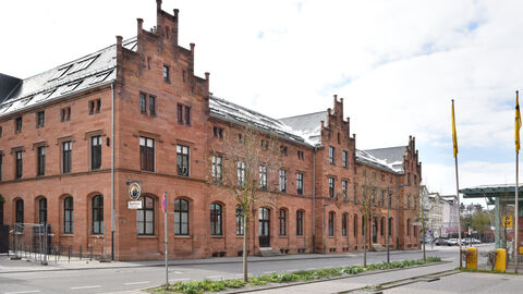 Der zweite Preis des Hessischen Denkmalschutzpreises 2022 für transformatives Bauen ging an Kai Laumann. Er hat die Alte Post und das ehemalige Telegraphenamt in Gießen zu einem Ort der Gastronomie, Wissenschaft, Gesundheit und Dienstleistungen gemacht. Die Alte Post mit Telegraphenamt in Gießen von außen: Ein großer, langgezogener rötlicher Bau mit schmuckvollen Giebeln