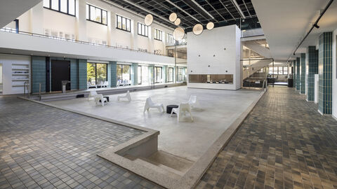 Blick ins restaurierte ehemalige Hallenbad Ost in Kassel Blick ins restaurierte ehemalige Hallenbad Ost in Kassel: gefliester Boden, kunstvolle Lichtinstallationen, Stühle, wo früher Wasser war