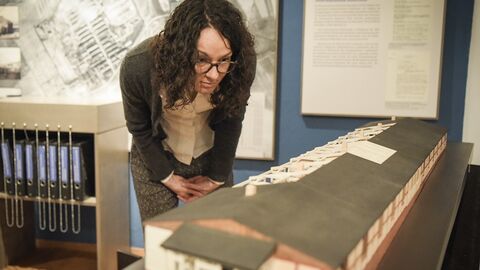 Ministerin Dorn schaut sich ein Modell der Baracken an.