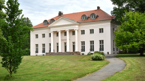 Das renovierte Schloss Schönburg in Hofgeismar Das renovierte Schloss Schönburg von außen: Ein weißes herrschaftliches Gebäude mit Säuleneingang