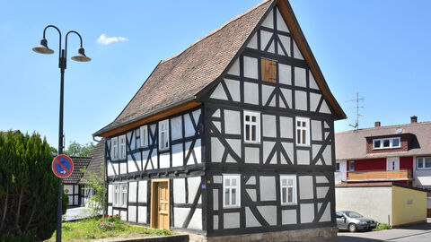 Das ehemaliges Forsthaus in Staufenberg-Treis von außen; ein freistehendes braunweißes Fachwerkhaus mit braunem Spitzdach