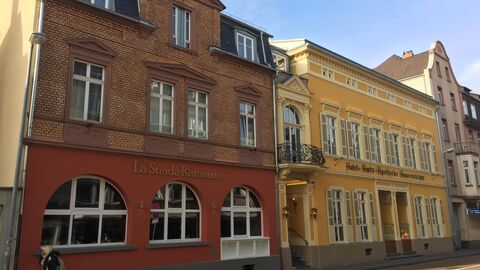 Da Hotel Amts-Apotheke in Limburg von außen: Ein gelbes, herrschaftliches Gebäude mit Flügelfenstern