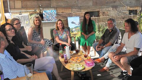 Ministerin Dorn sitzt im Kreis von Kulturschaffenden und unterhält sich