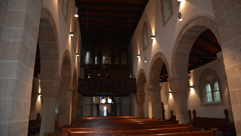 Blick in die Marienbasilika Wilhelmshausen: Helle Steinbögen, dunkle Kirchenbänke