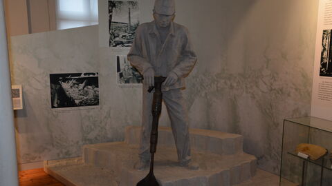 Die Ausstellung präsentiert die Arbeitsprozesse zur Gewinnung und Verarbeitung des Rohstoffs Ton. Lebensgroße Figur eines Arbeiters, der Ton sticht, im Glas- und Keramikmuseum Großalmerode