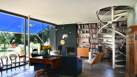 Blick in ein Zimmer des Wohnhauses Mäckler: Man sieht eine stählerne Wendeltreppe, eine große Fensterfront und Wohnzimmermöbel