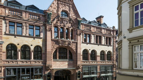 Die Fassade des Wiesbadener Pressehauses von außen, ein rötlicher Bau im Stil des Neobarocks und des Jugendstils