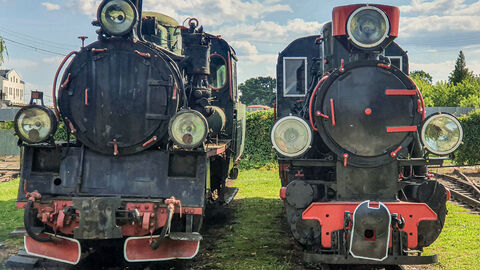 Zwei historische Lokomotiven stehen auf zwei Gleisen nebeneinander