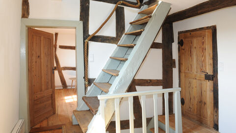 Blick ins Hünstetter Fachwerkhaus: Eine freie Treppe im holzverkleideten Flur