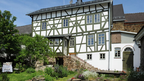 Das Fachwerkhaus Hünstetten von außen, ein hübsches Haus mit braunem Fachwerk und grünen Fensterläden