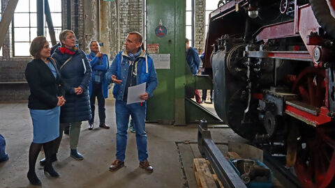 Historische Eisenbahnen faszinieren bis heute Staatssekretärin Ayse Asar schaut sich eine historische Lokomotive an