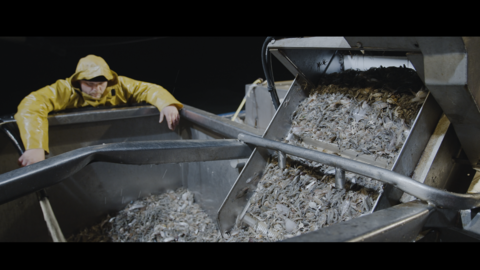 Szene aus "Ein Leben auf See" Szene aus "Ein Leben auf See": Ein Fischermann im gelben Schutzanzug überwacht einen Fang Fische