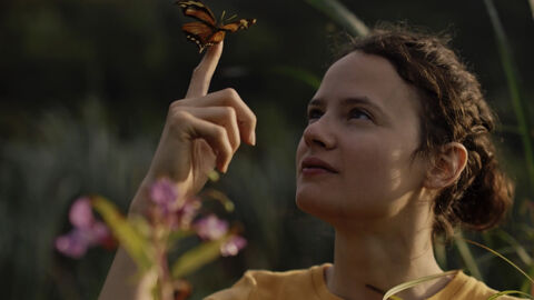 Szene aus "Servus Papa - See you in hell" Szene aus "Servus Papa - See you in hell": Eine junge Frau hat einen Schmetterling auf dem Zeigefinger