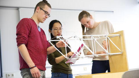 Beim Preisträgerprojekt "Modul Baukonstruktion" geht es um den Entwurf und die Konstruktion von Bauwerken. Studierende arbeiten an einem Holzmodell.