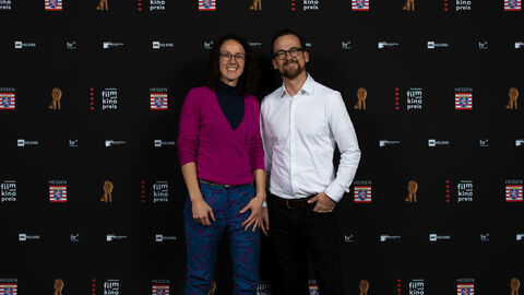 MInisterin Dorn und Produzent Jonas Dornbach stehen vor einer Fotoleinwand.