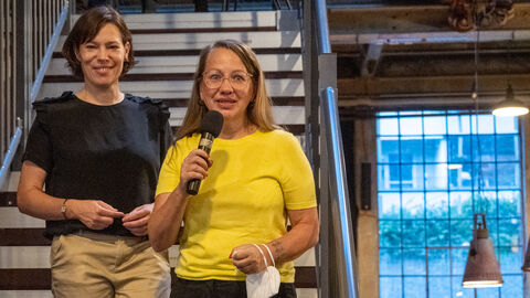 Jutta Peters (links) und Jutta Feit von jip film & verleih bekommen den Newcomerpreis 2022. Jutta Peters (links) und Jutta Feit von jip film & verleih stehen bei einer Filmpremiere auf einer Treppe und begrüßen das Publikum
