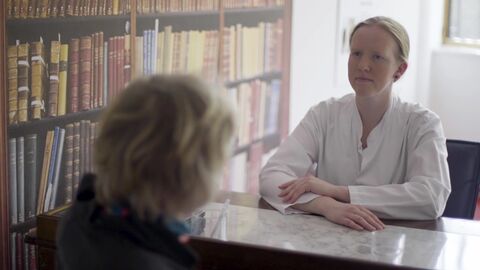 Das Projekt "Klug entscheiden - sicher behandeln" an der Uni Marburg soll Medizinstudierende im Praktischen Jahr (PJ) unterstützen und so zu mehr Patientensicherheit beitragen.  Eine Medizinstudierende sitzt einer Person am Schreibtisch gegenüber.