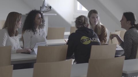 Studierende sitzen zusammen und arbeiten.