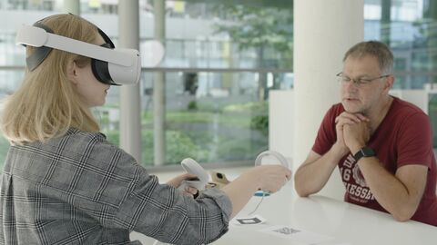Das Projekt macht die Studierenden mit Technologien der virtuellen Realitäten (Virtual Reality, VR) und erweiterten Realitäten (Augmented Reality, AR) vertraut. Eine Studentin sitzt mit einer VR-Brille ihrem Professor gegenüber.