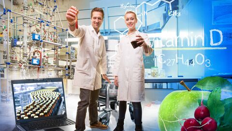 Ein Mann und ein Frau im Laborkittel stehen inmitten einer computergenerierten Landschaft mit wissenschaftlichen Symbolen, Computern, Formeln und Geräten