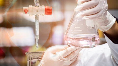 Eine Person hält einen Behälter im Labor.